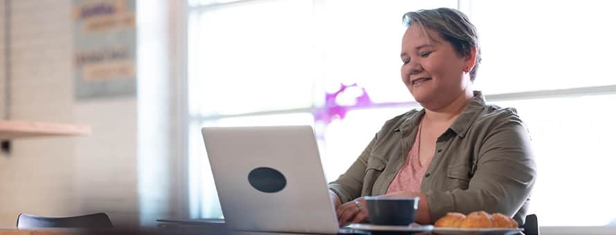 An SNHU student typing on a laptop