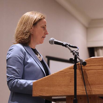 Manchester Mayor Joyce Craig speaking into a microphone at a podium.