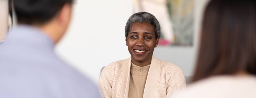 A professional with a master’s in psychology meeting with two people.