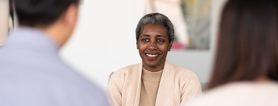 A professional with a master’s in psychology meeting with two people.