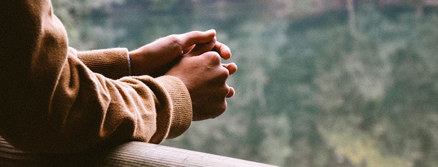 A person's hands clasped together