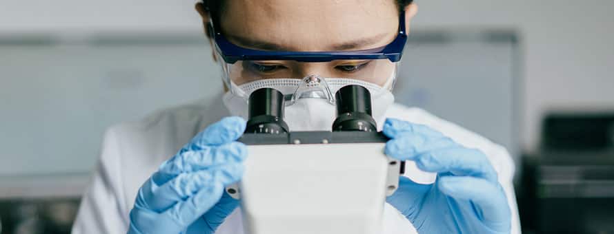 A doctor looking into a microscope