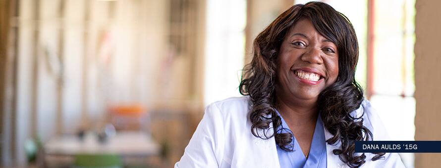 A MS in Nursing graduate wearing a white coat. With the text Dana Aulds '15G