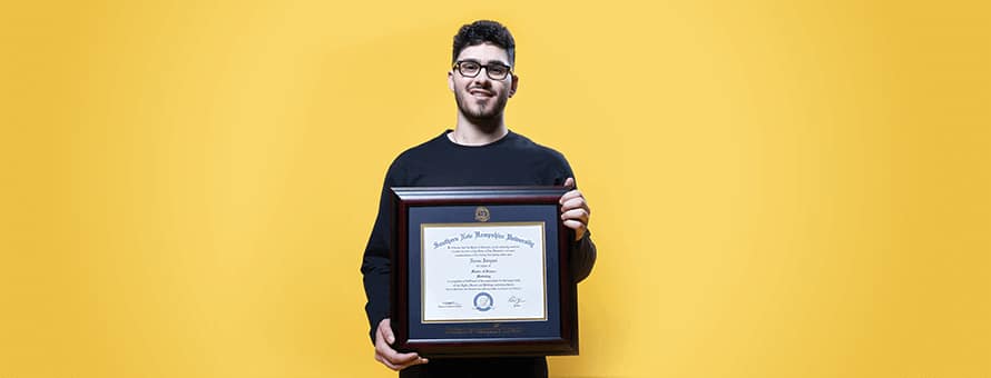 Naeem Jaraysi holding his diploma from SNHU. 