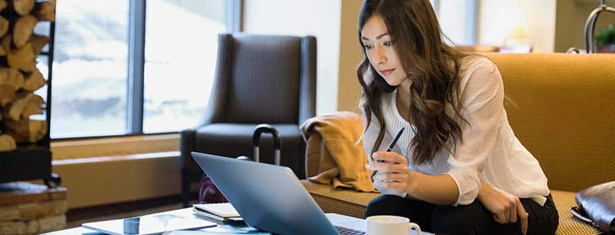 Woman sitting on a couch looking at her laptop