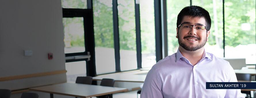 Sultan Akhter standing in a classroom with text Sultan Akhter '19