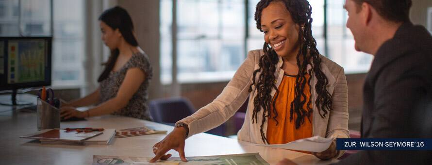 Zuri Wilson-Seymore discussing an infographic with a colleague with text Zuri Wilson-Seymore '16