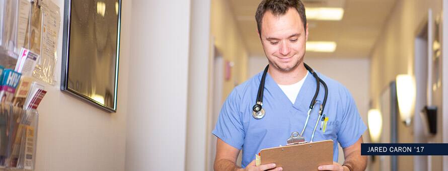 SNHU graduate Jared Caron reviewing a patients chart. With the text Jared Caron '17