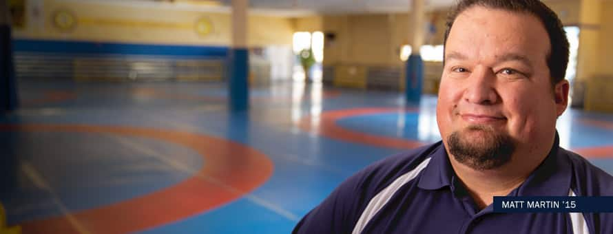 A Basketball coach in front of a basketball court with text "Matt Martin '15"