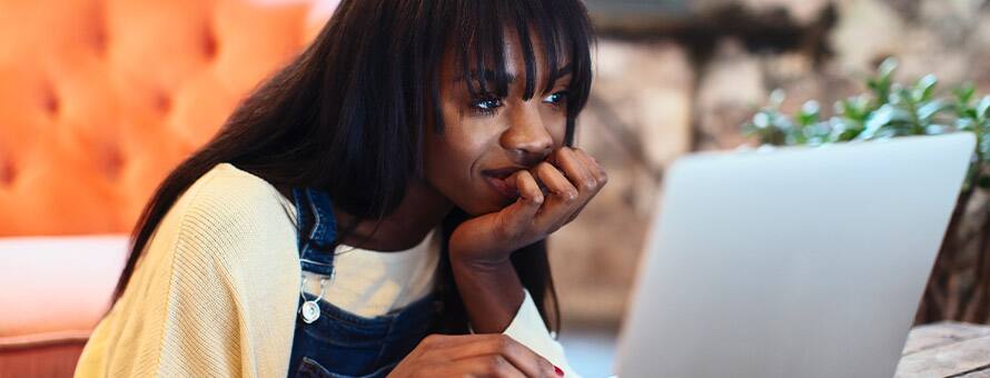 A first generation college student working on her degree with a laptop.