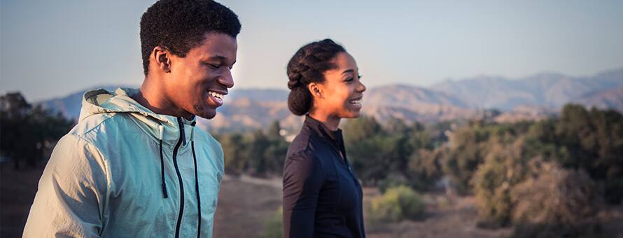 A man and a woman walk and discuss facing covid pandemic fatigue