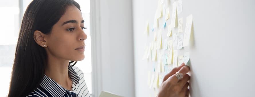 A woman reviewing her personal growth and professional development plan on sticky notes