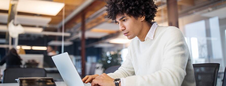 A student researching what nonprofit university means on a laptop.