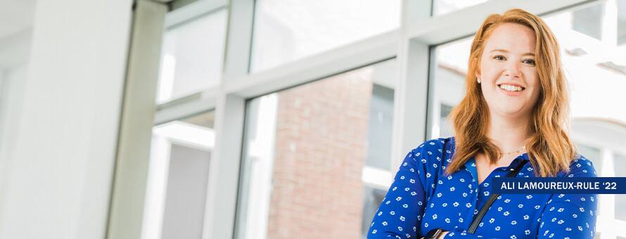 Ali Lamoureux-Rule, online bachelor's in healthcare administration student and future graduate of the 2022 class, standing in a sunny corridor.