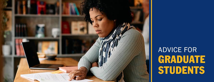 A student studying her textbook as she pursues a master's degree with the text Advice for Graduate Students