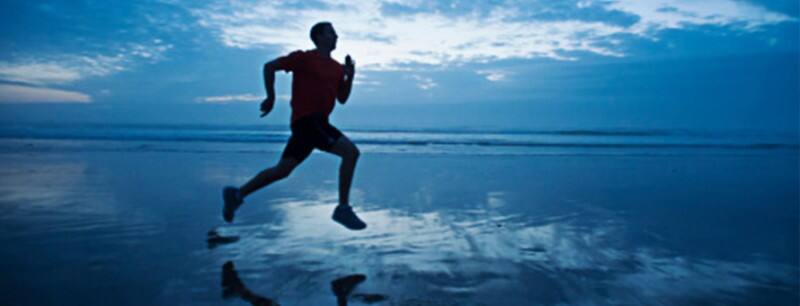 Runner sprinting across a beach