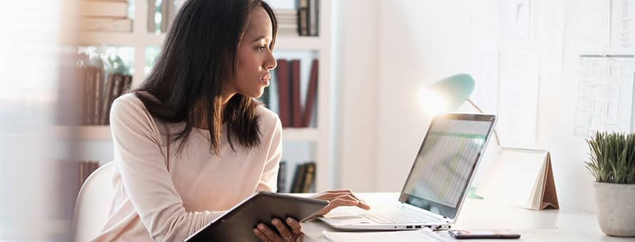 A woman working on a laptop and tablet computer on Trailhead's free online learning platform.