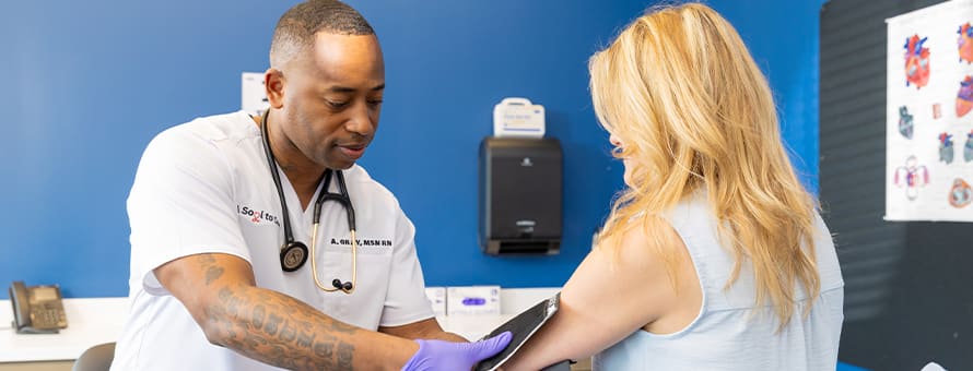 SNHU alum, Anthony Gray '21, who earned an MSN degree, taking a patient's blood pressure.