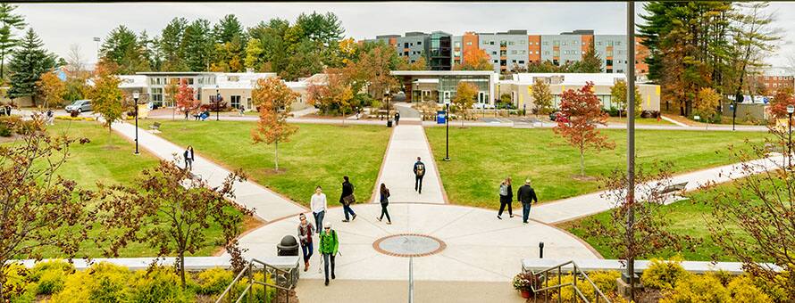 A college quad with people walking along a series of sidewalks in a geometric pattern.