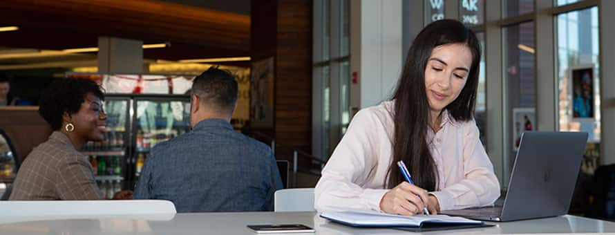 A student taking notes while working on a assignment