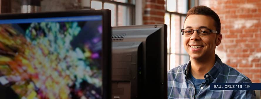 Saul Cruz sitting in front of a computer monitor with text Saul Cruz 16' 19'