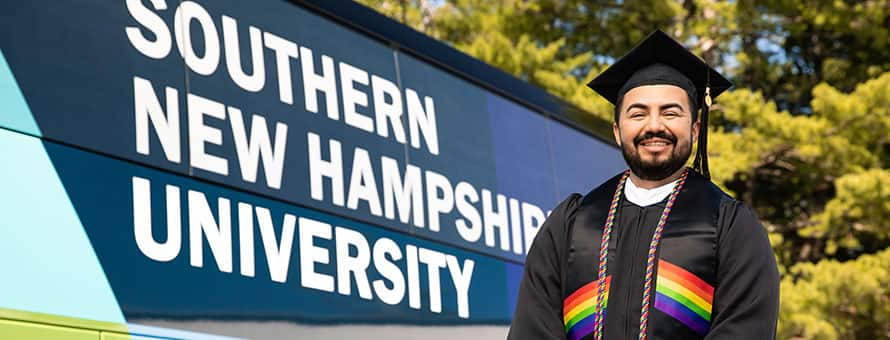 SNHU Student Jesus Suarez in front of the SNHU Bus. 