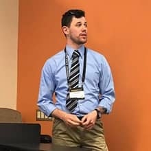 An undergraduate student presenting his research at a conference.