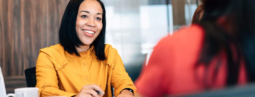 A woman speaking to another employee in her role as a human resources manager.