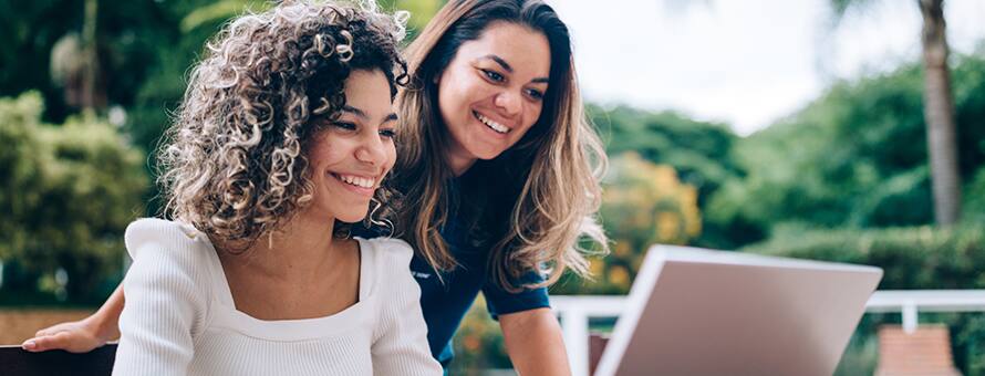 A high school senior on a laptop applying to college using the common app with her mother