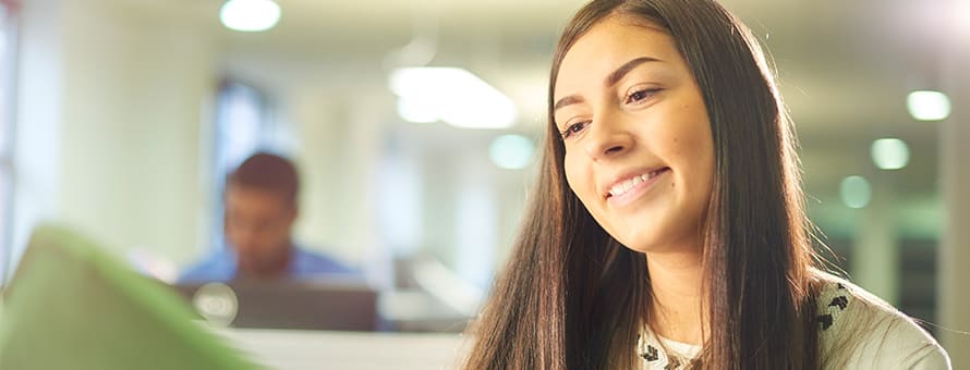 A student smiling while working at her work-study job