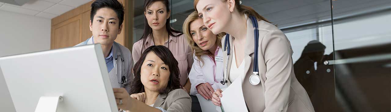 A group of medical professionals looking at a computer screen