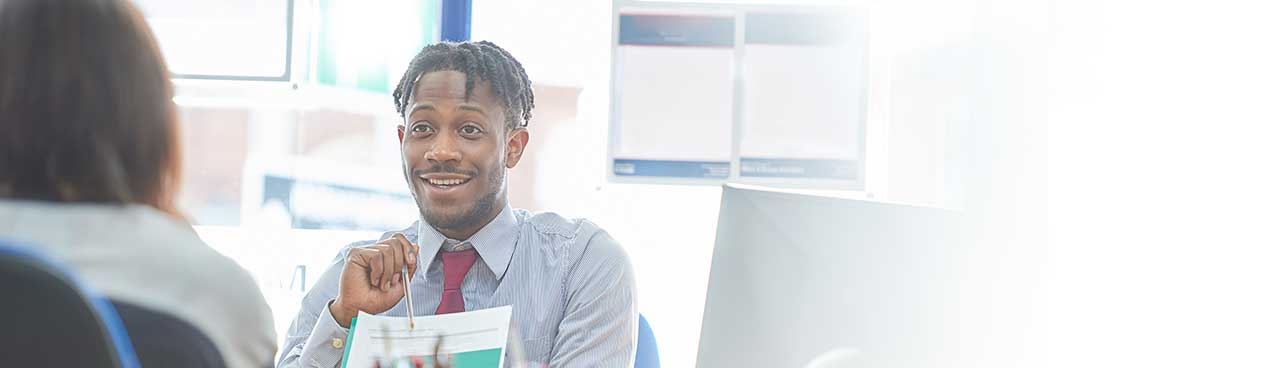 A business man pointing to a report with a pencil