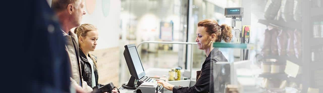 A Walgreens employee helping customers at the register