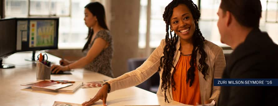 Zuri Wilson-Seymore, 2016 graduate of the online Master's in English and Creative Writing program, working with a colleague on a creative project.