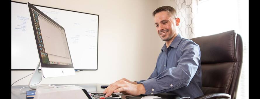 A man working at his desk on his computer.