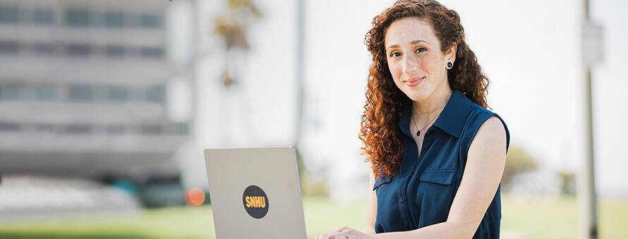 SNHU student on her laptop smiling 