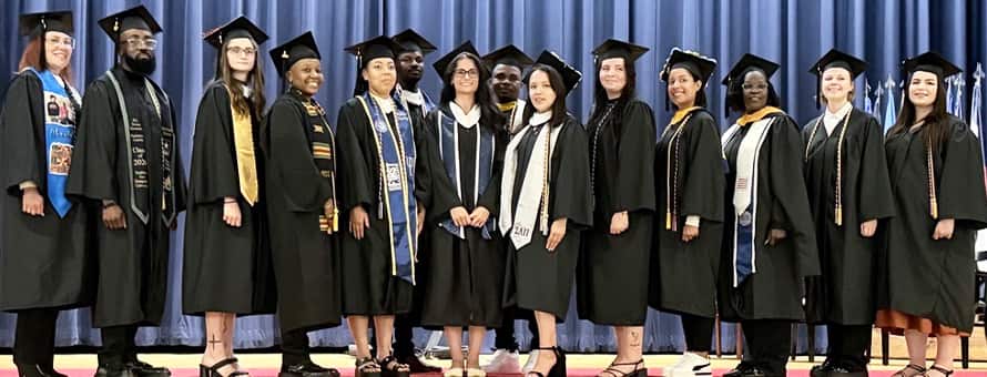 A number of SNHU graduates in caps, gowns and regalia at Fort Campbell's combined colleges ceremony.