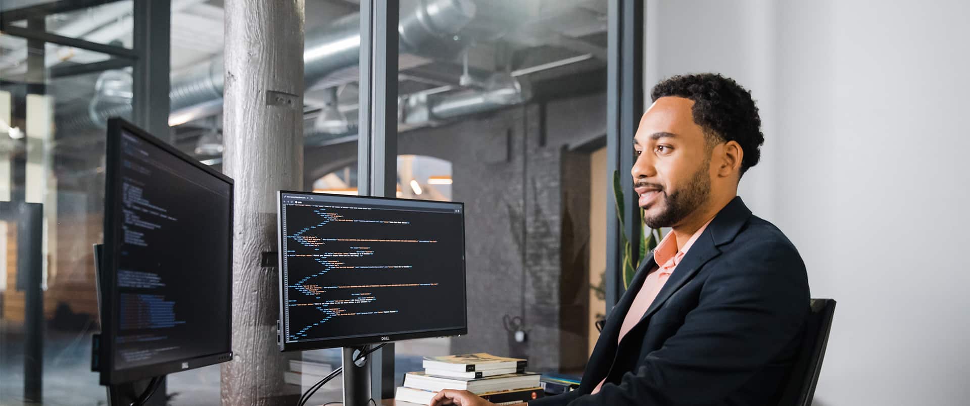 Gary Walker, who earned his degree from SNHU in 2022, wearing dark suit and sitting at a desk with two computer monitors.