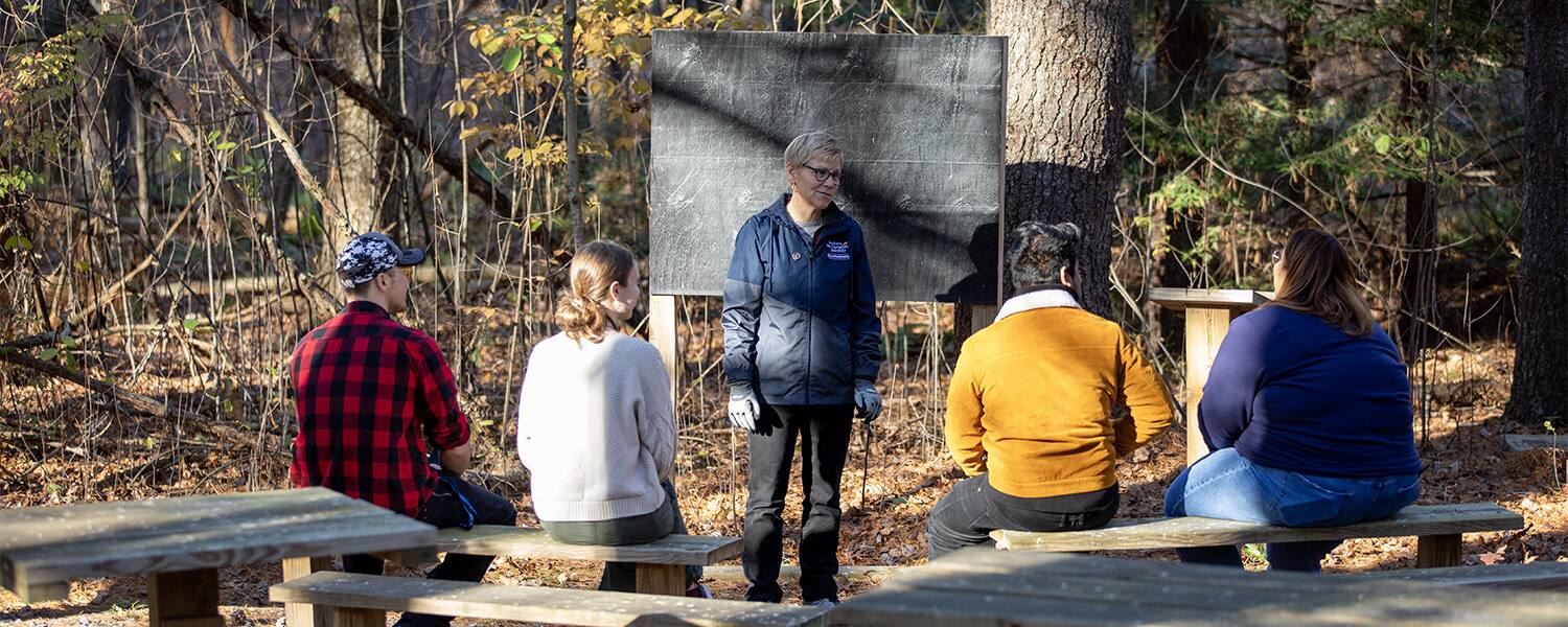 Instructor teaching students in an outdoor classroom.