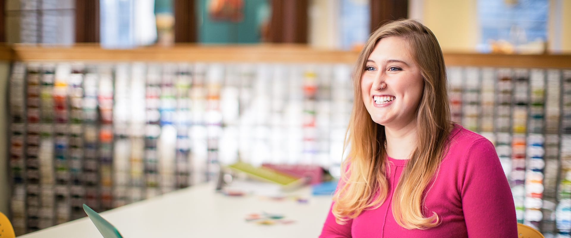 2015 online degree graduate Caitlyn Carey, working from a laptop on her couch.