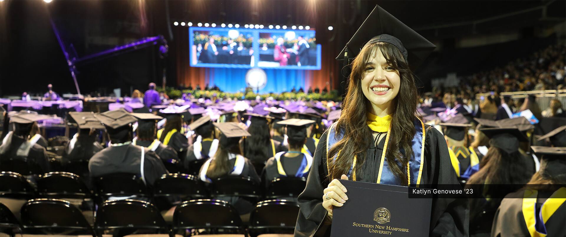 Katlyn Genovese, who earned her bachelor's in criminal justice with a concentration in criminology in 2023, wearing her cap and gown and holding her diploma at the SNHU commencement ceremony.