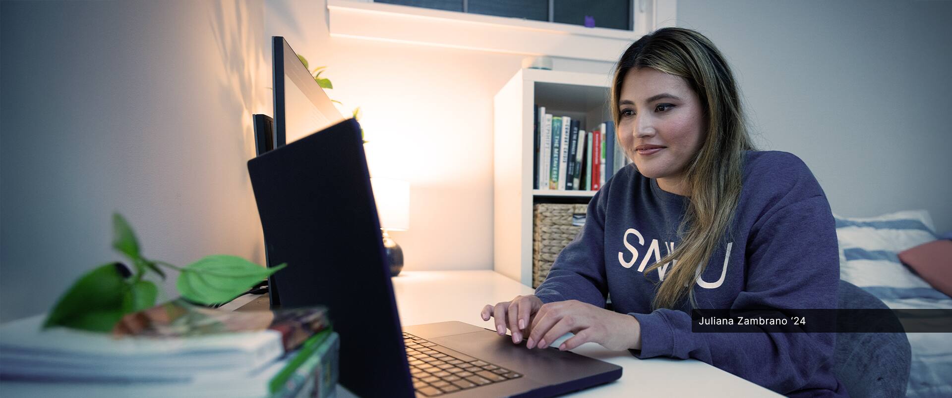 Juliana Zambrano '24 sitting at a desk while using a laptop.