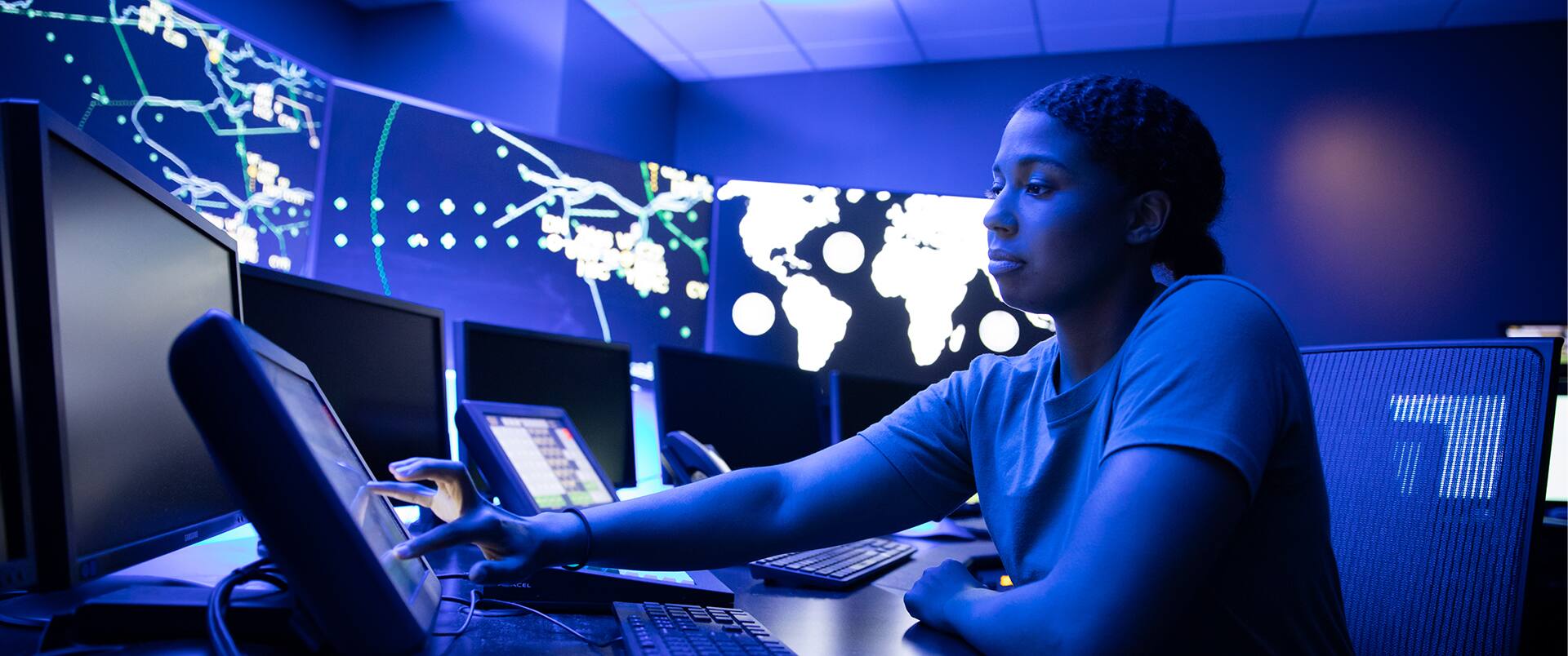 Bethanie Thomas, working from a high-tech office space with digital maps and coordinates on the walls all around her.