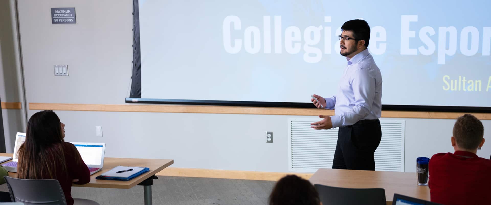 Frederico Curty, who earned his master's in higher education administration from SNHU in 2023, wearing his cap and gown and holding his diploma.