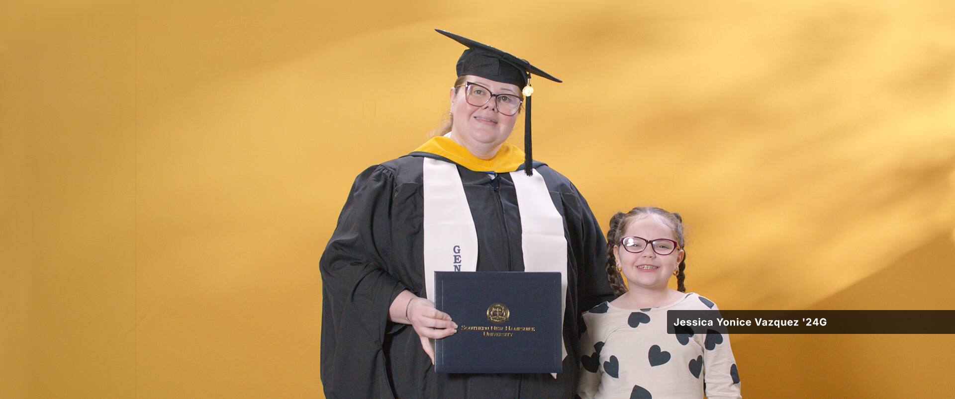 Jessica Yonice Vazquez, a 2024 graduate who earned her master’s in human resource management at SNHU standing with her daughter.