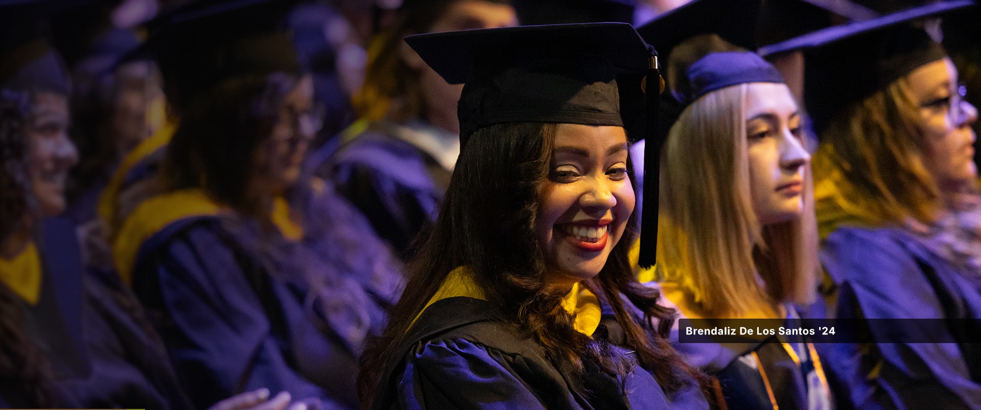Brendaliz De Los Santos, who earned her master's in digital marketing from SNHU in 2024, wearing her cap and gown at the SNHU commencement ceremony.