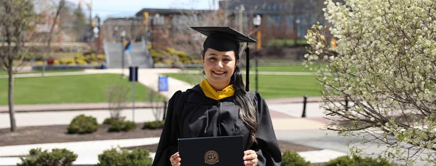 Maisoon Mir dressed in a graduation cap and gown, at SNHU, an institutionally accredited university, celebrating her Master of Science in Information Technology.