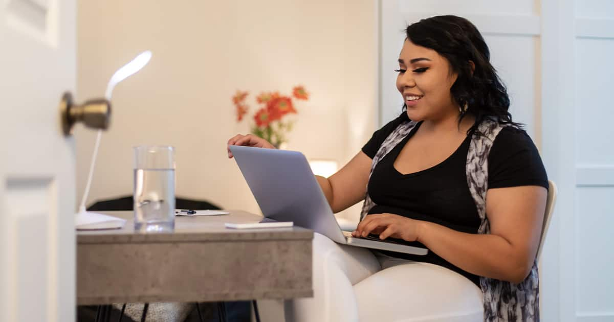 An adult learner discovering how online courses work, sitting at a desk with a laptop.