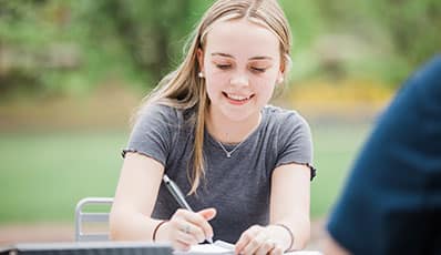 A student writing in a notebook