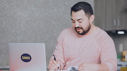 Jesús Suárez, a 2021 online graphic design graduate, working on his laptop